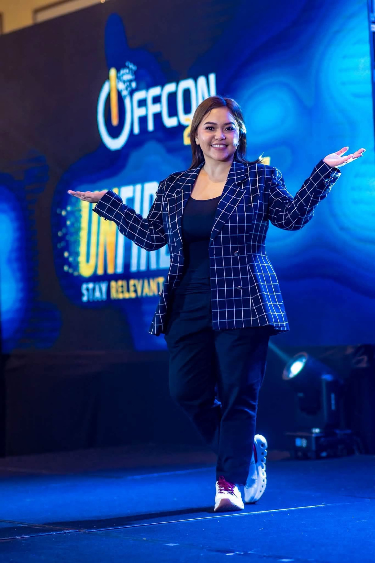 CJ Cajoles speaking on stage at the OFFCON freelancing conference